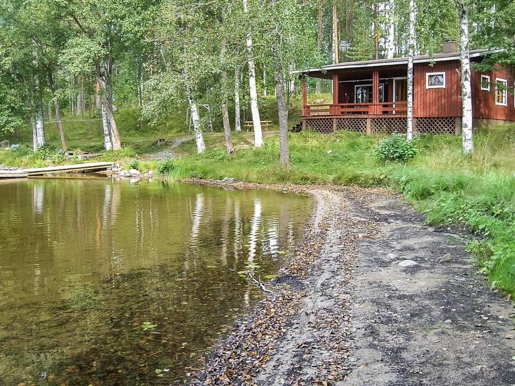 a cabin in the woods next to a body of water at Holiday Home 2235 by Interhome in Savonranta