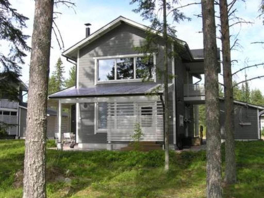 una casa gris con árboles delante de ella en Holiday Home Paltamon golfhovi b by Interhome en Paltamo