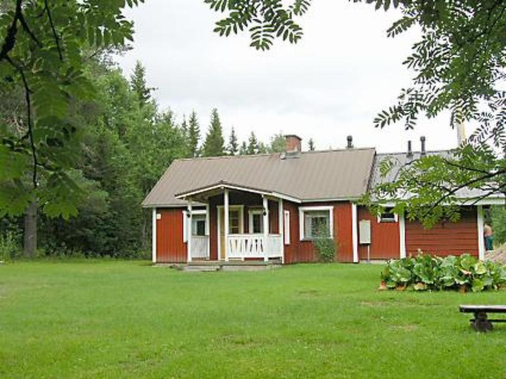 een rood-wit huis met een groene tuin bij Holiday Home Välitalo by Interhome in Inkee