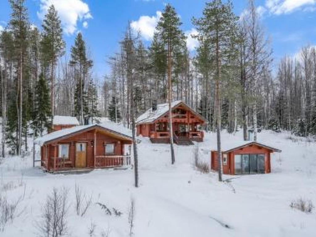 two log cabins in the snow in a forest at Holiday Home Ahonranta by Interhome in Juntusranta
