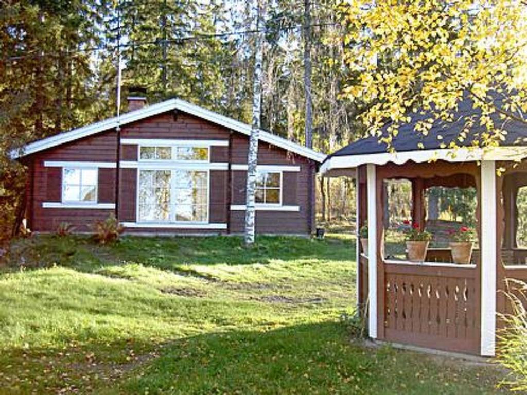 une petite maison avec une clôture et un kiosque dans l'établissement Holiday Home Alahuone by Interhome, à Pätiälä