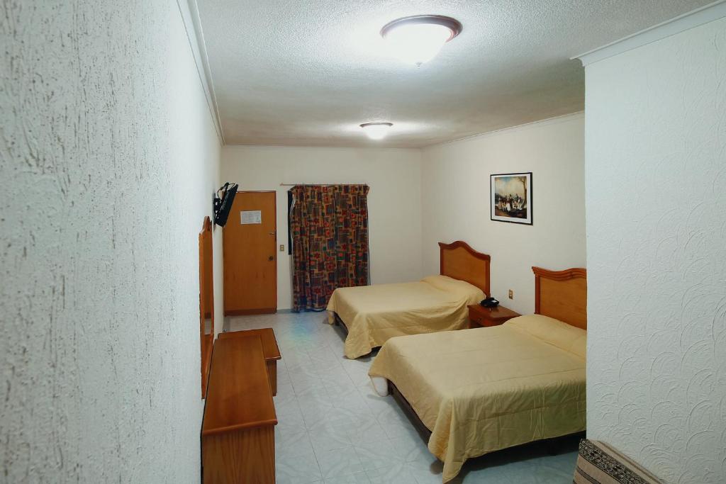 Postel nebo postele na pokoji v ubytování HOTEL EL CONQUISTADOR MONARCA.