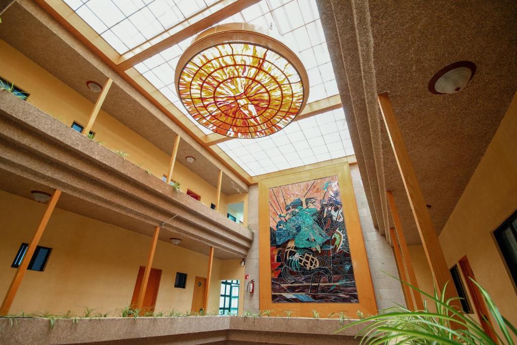 un gran vestíbulo con una gran lámpara de araña en un edificio en HOTEL EL CONQUISTADOR MONARCA., en Zitácuaro