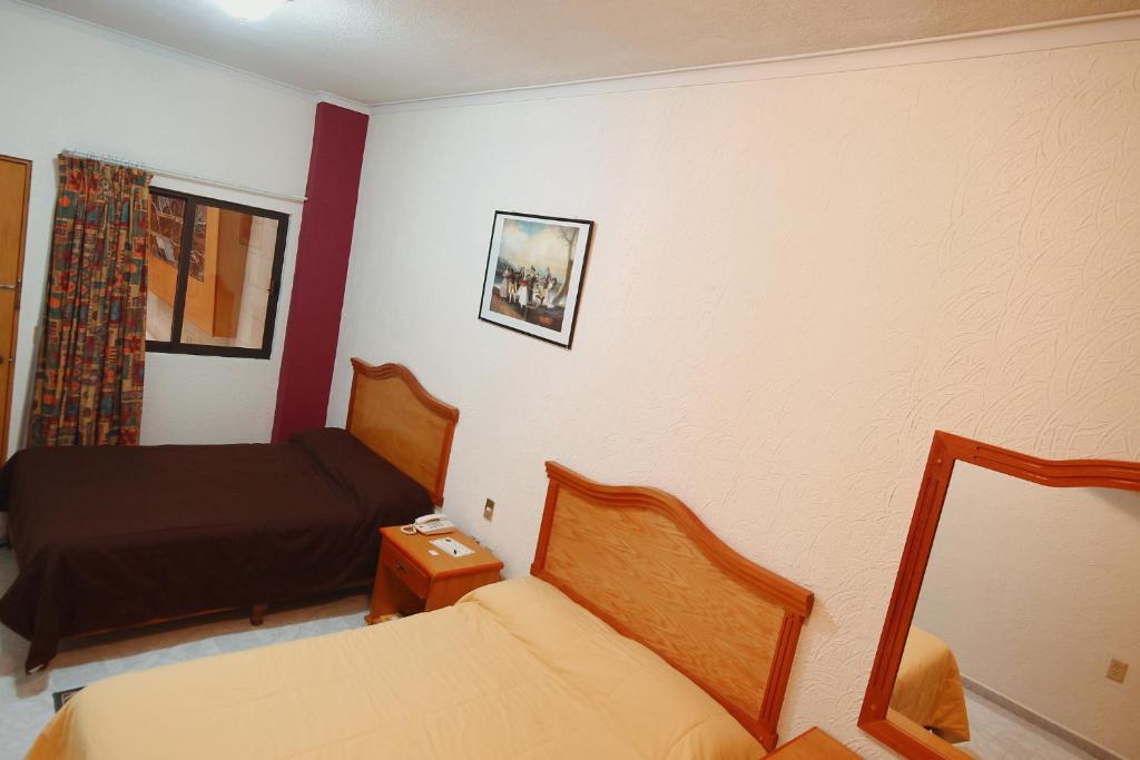 Postel nebo postele na pokoji v ubytování HOTEL EL CONQUISTADOR MONARCA.