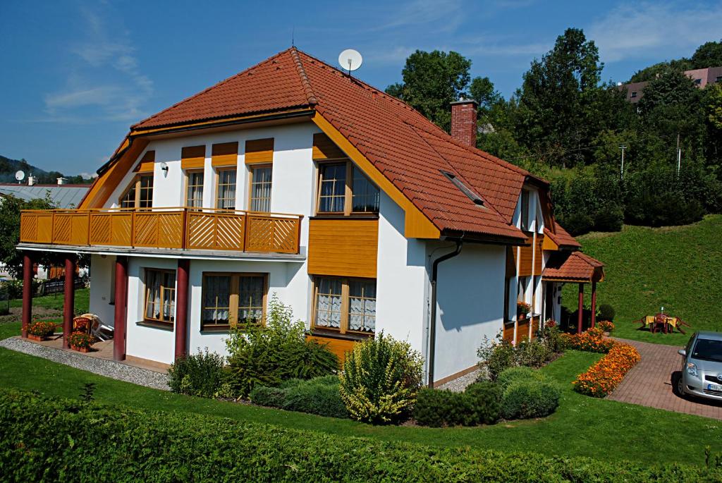 une maison blanche avec un toit rouge dans l'établissement Pension B&B, à Vrchlabí