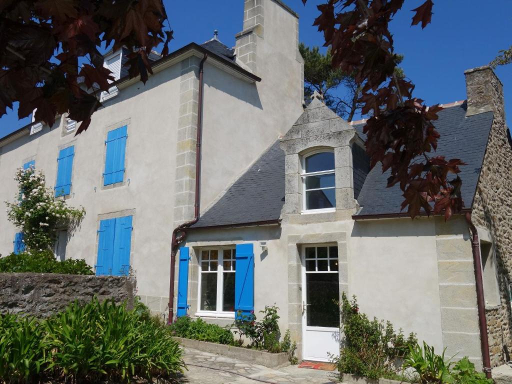 una vieja casa blanca con persianas azules en Holiday Home La Rodière by Interhome en Saint-Lunaire