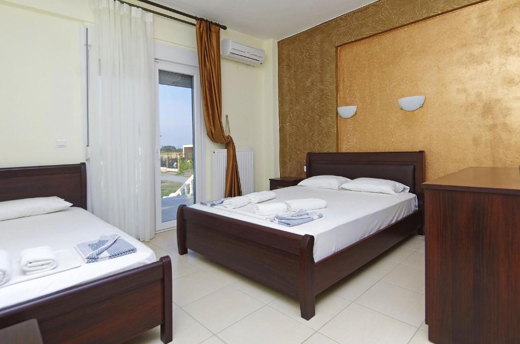 pokój hotelowy z dwoma łóżkami i oknem w obiekcie Hotel Paris w Paralii Katerinis