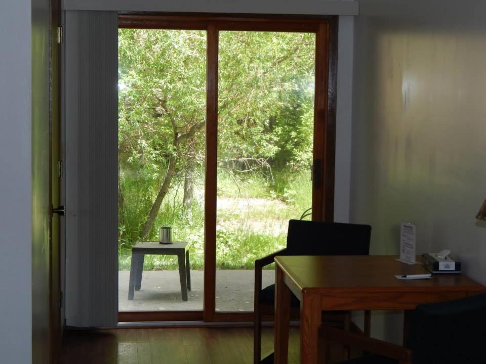 an open door with a table and a chair in a room at The Brookside Motel / Mt. Rushmore in Keystone