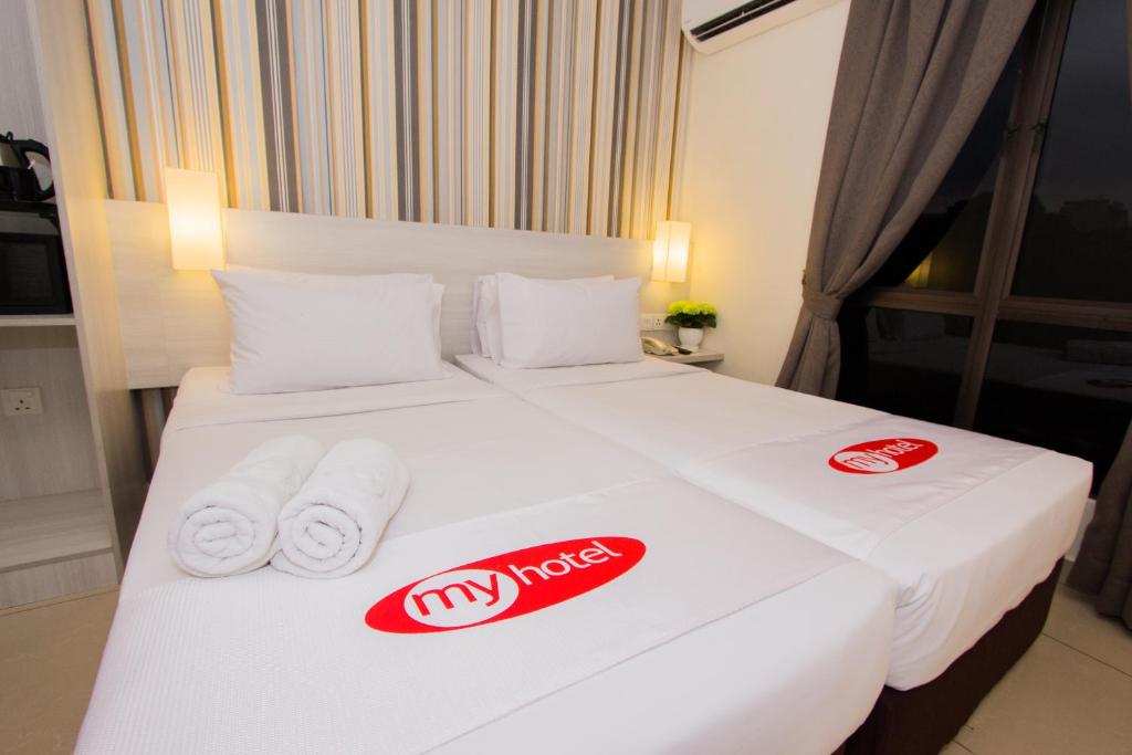 a hotel room with a bed with towels on it at My Hotel @ Sentral in Kuala Lumpur