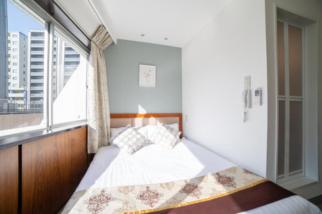 Postel nebo postele na pokoji v ubytování Tabata Oji Hotel