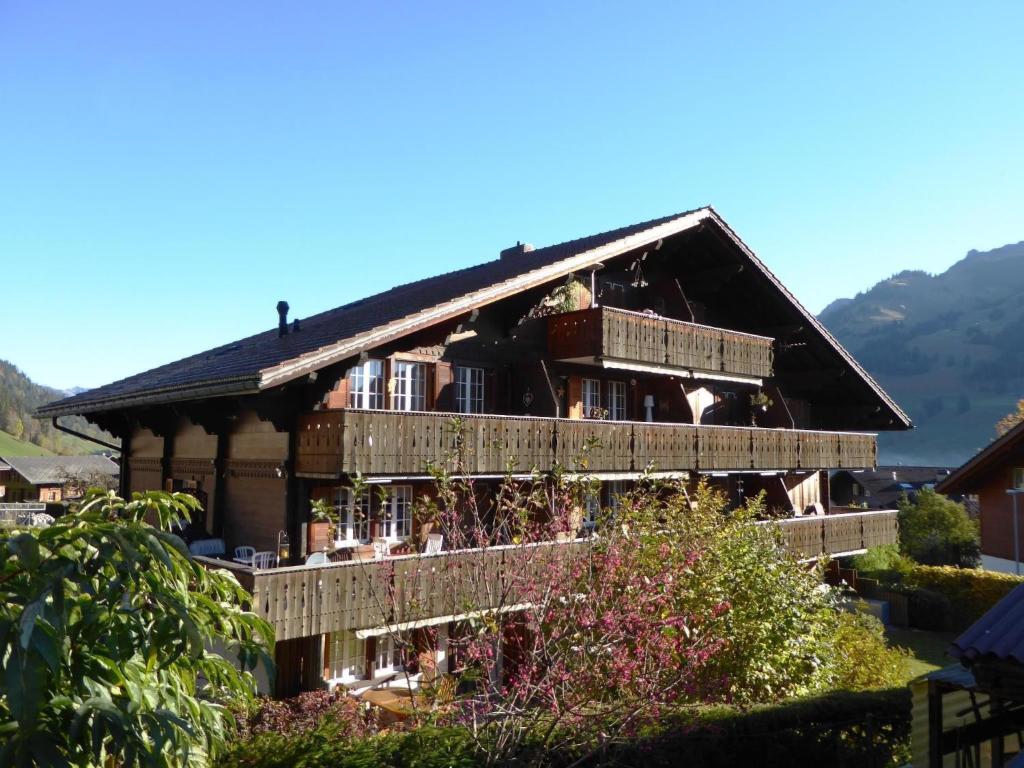 een groot houten huis met balkons en een berg bij Apartment Résidence Sonnegg - Herrli by Interhome in Zweisimmen