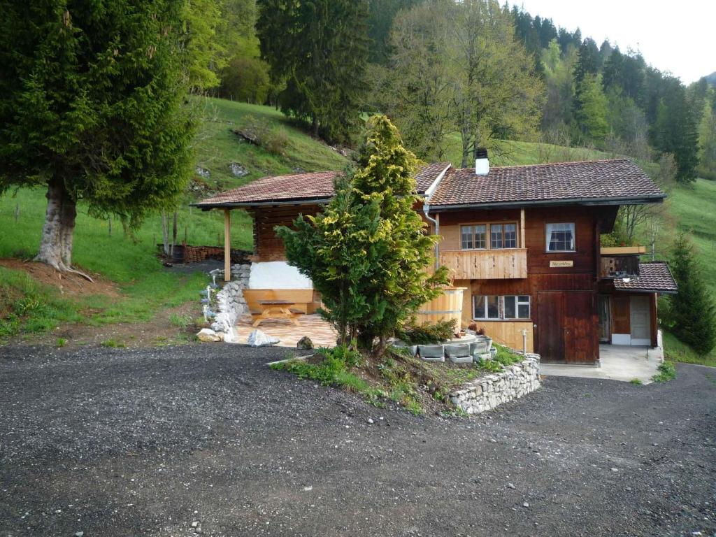 a house with a tree in front of it at Apartment Ferienhaus Niesen View by Interhome in Erlenbach im Simmental
