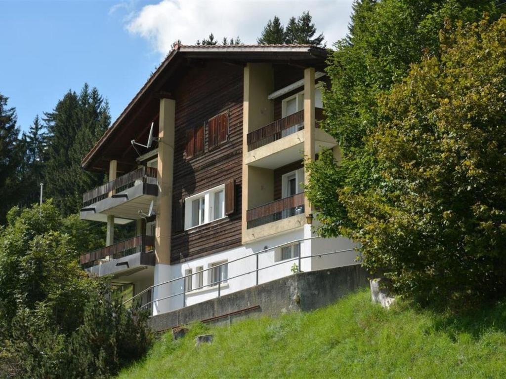 un edificio en la cima de una colina con árboles en Apartment Media by Interhome en Saanenmöser