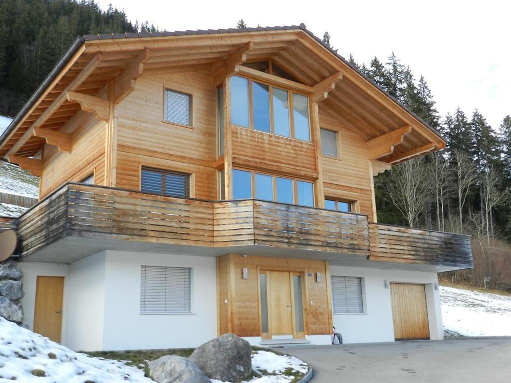 een blokhut met een balkon erboven bij Apartment Gletscherblick- Chalet by Interhome in Zweisimmen