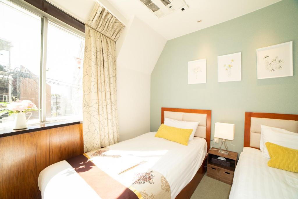 Postel nebo postele na pokoji v ubytování Tabata Oji Hotel