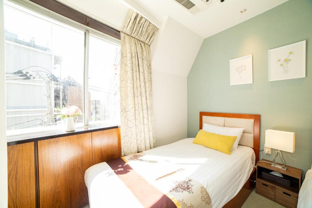 Postel nebo postele na pokoji v ubytování Tabata Oji Hotel