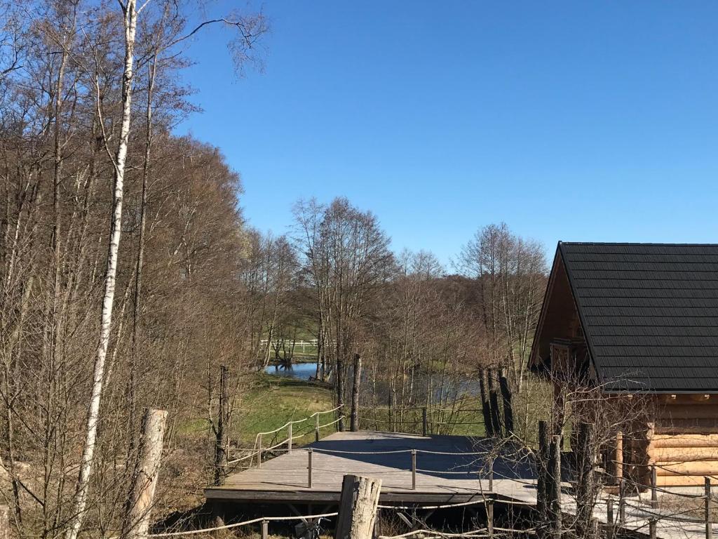 uma rampa de madeira que leva a uma cabana na floresta em Fjäll Stuga em Steninge