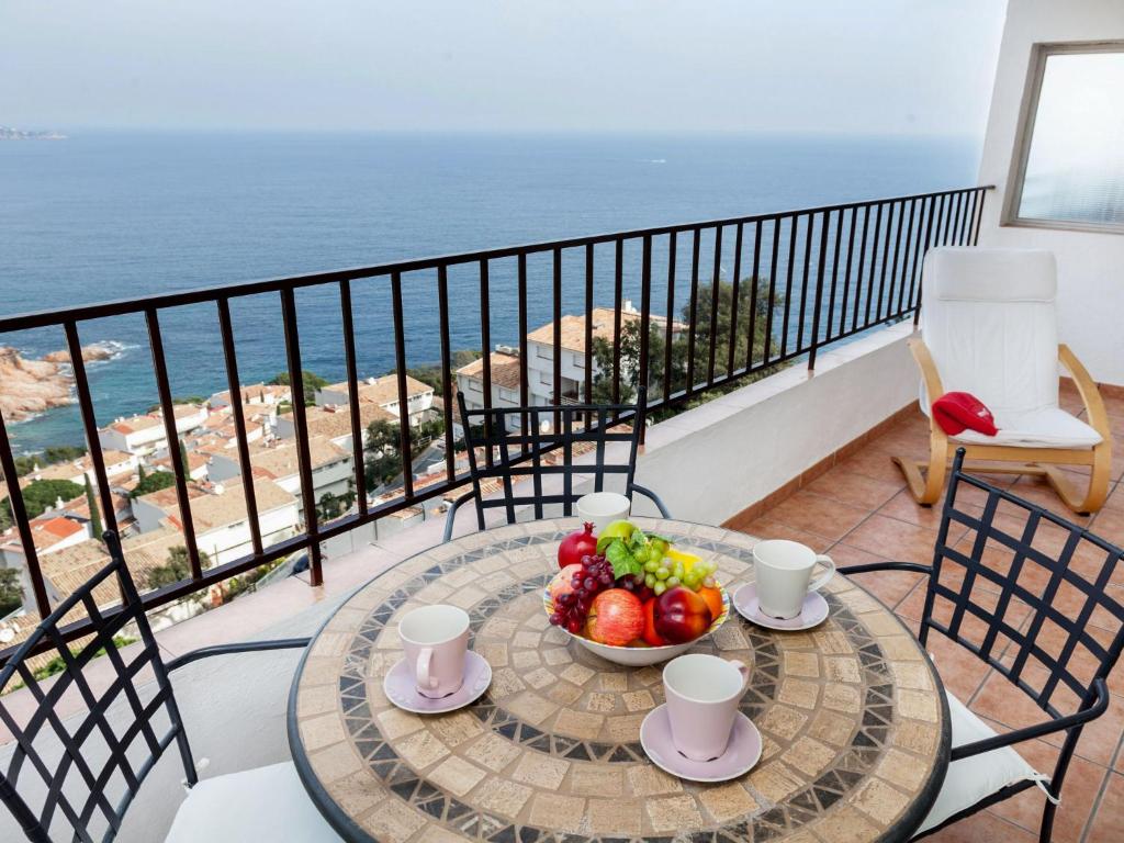 een tafel met een fruitschaal op een balkon met uitzicht op de oceaan bij Apartment Piscis by Interhome in Cañet de Mar