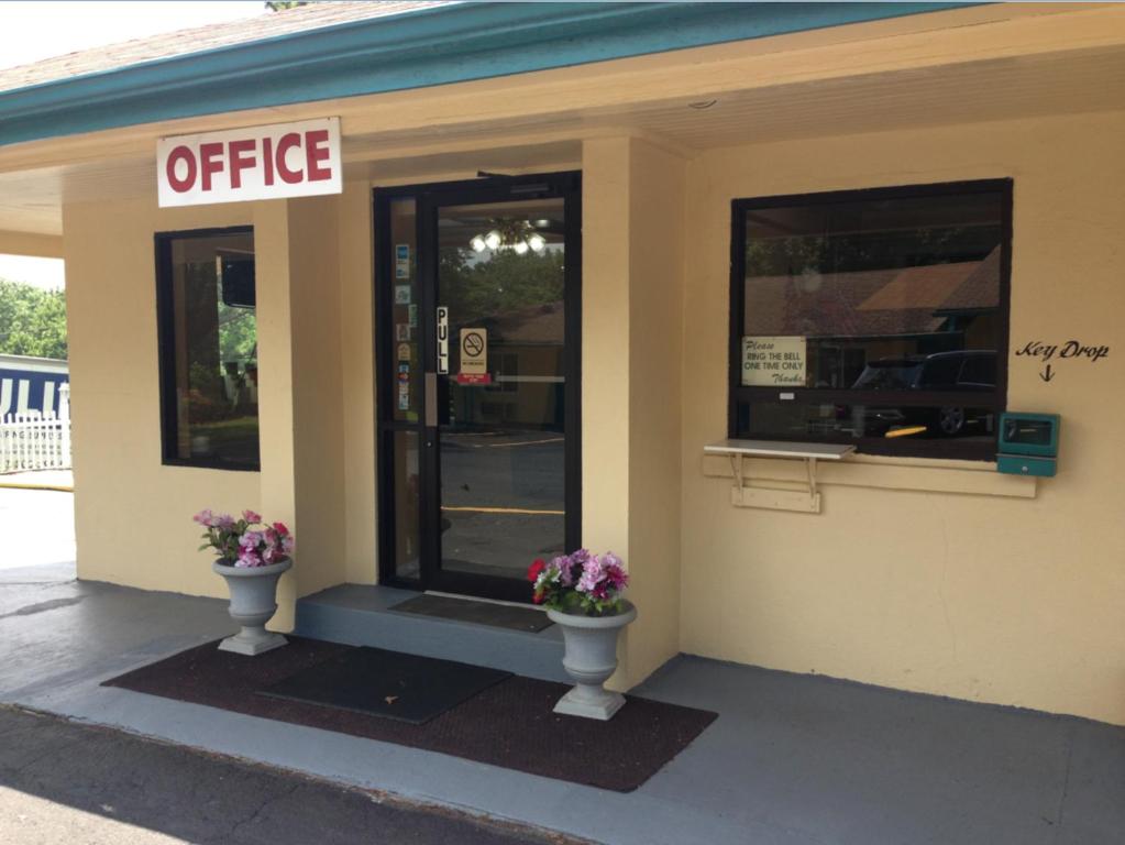 un bâtiment de bureau avec deux pots de fleurs devant lui dans l'établissement Economy Inn - Cullman, à Cullman