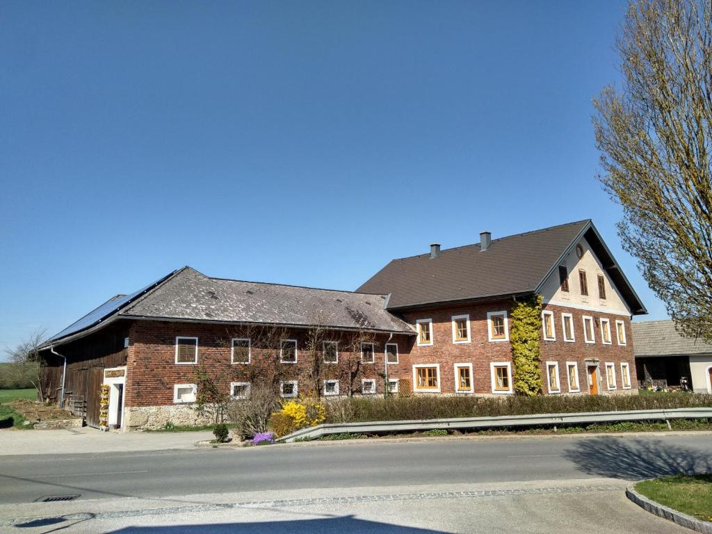 um grande edifício de tijolos com um telhado preto em Ferienwohnung Maringer em Ungenach