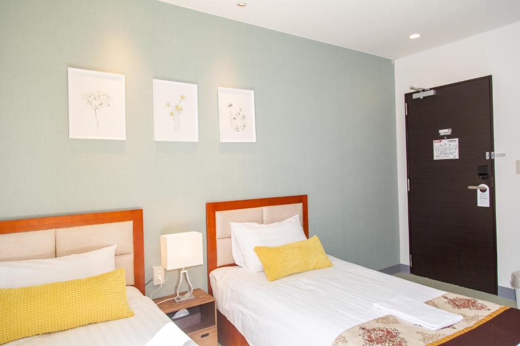 Postel nebo postele na pokoji v ubytování Tabata Oji Hotel