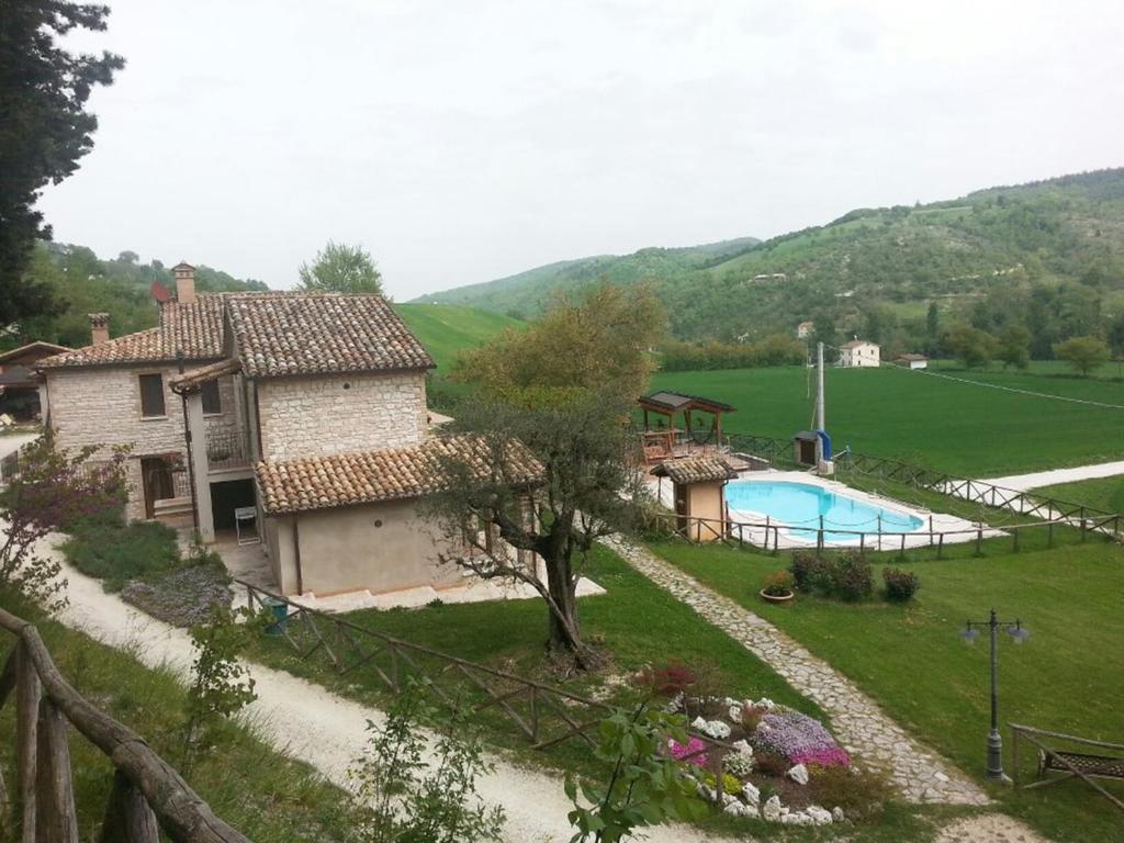 una vista exterior de una casa y una piscina en Agriturismo Il Casale, en Pergola
