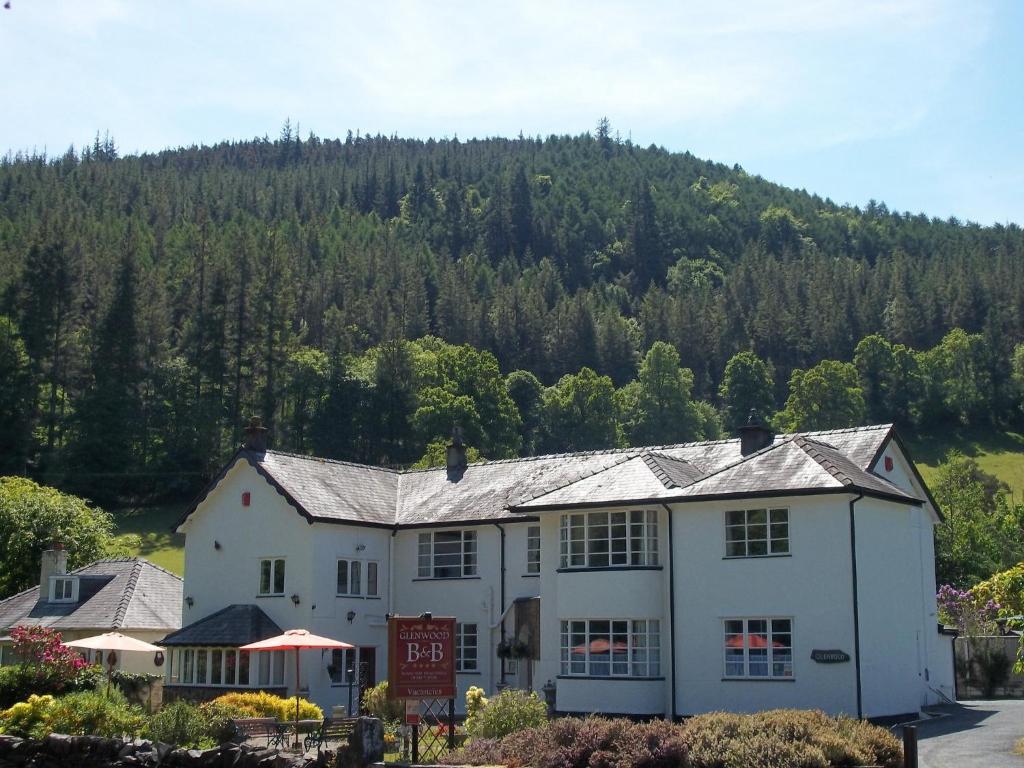 a white house with a mountain in the background at Glenwood Guesthouse Betws-y-coed in Betws-y-coed