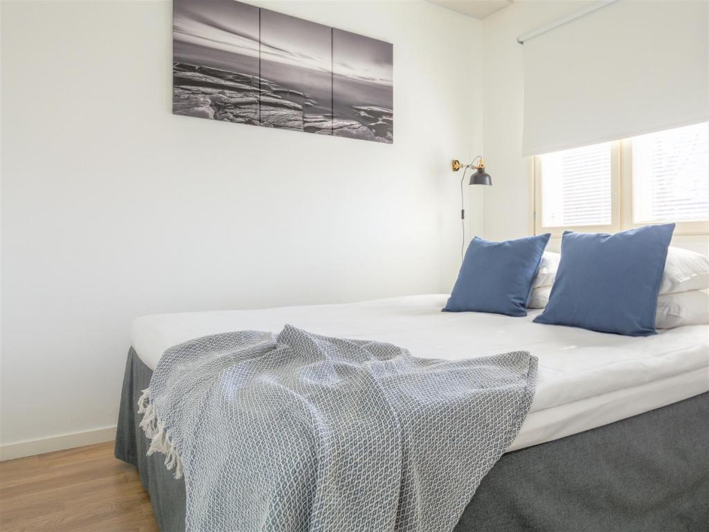 ポリにあるTorget Apartment Länsiporttiのベッドルーム(白いベッド、青い枕付)