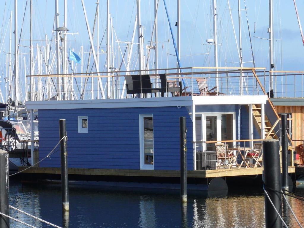 a blue boat parked at a dock in the water at Hausboot Bosse in Burgstaaken