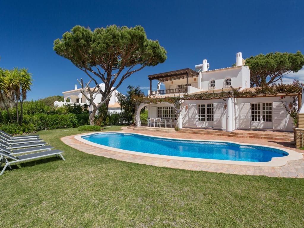 a villa with a swimming pool in front of a house at Villa Villa Verde by Interhome in Vilamoura