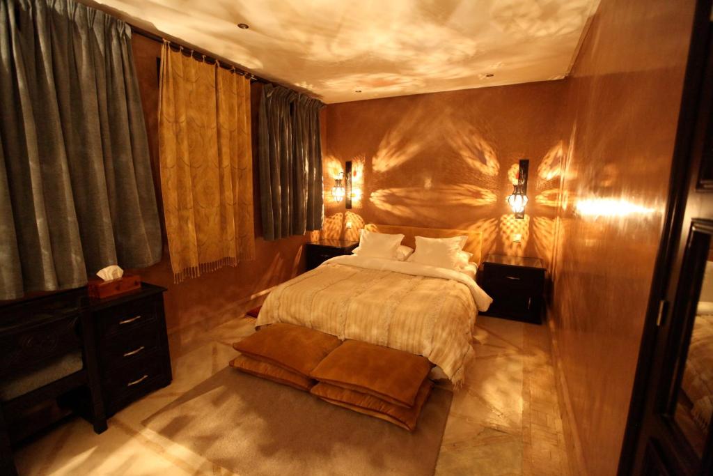 a bedroom with a large bed and a wooden wall at Riad Dar Haven in Tamraght Ou Fella