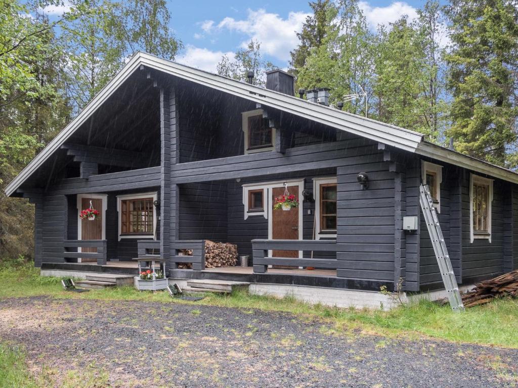uma casa preta com um alpendre e um quintal em Holiday Home Rukantaika 1a by Interhome em Virkkula