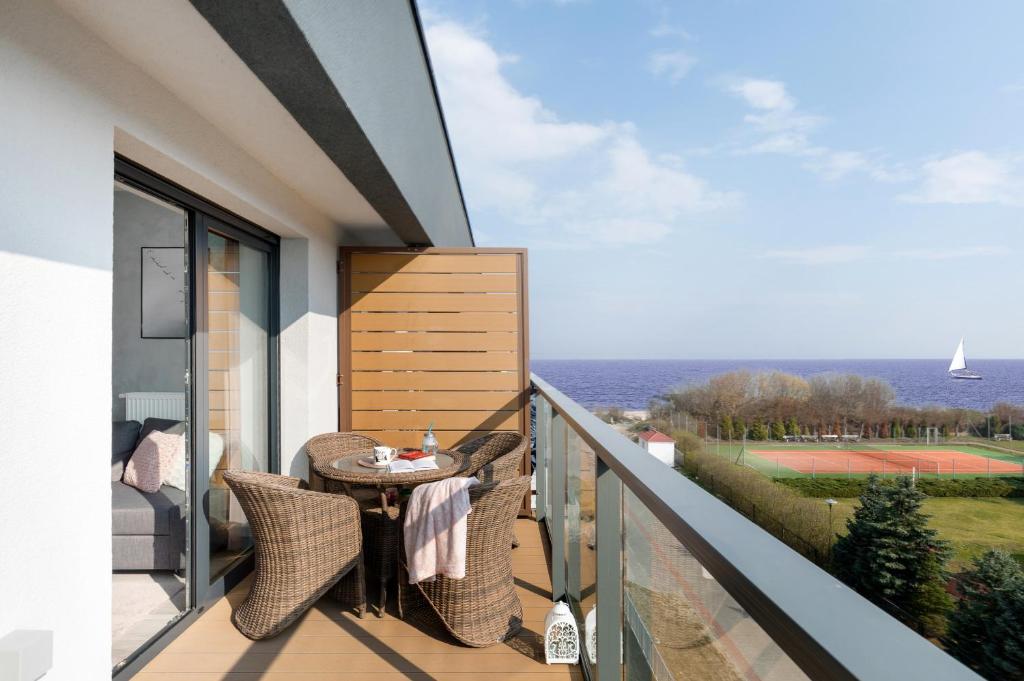 a balcony with a table and a view of the ocean at Apartamenty Gardenia Seaside by Renters in Dziwnów