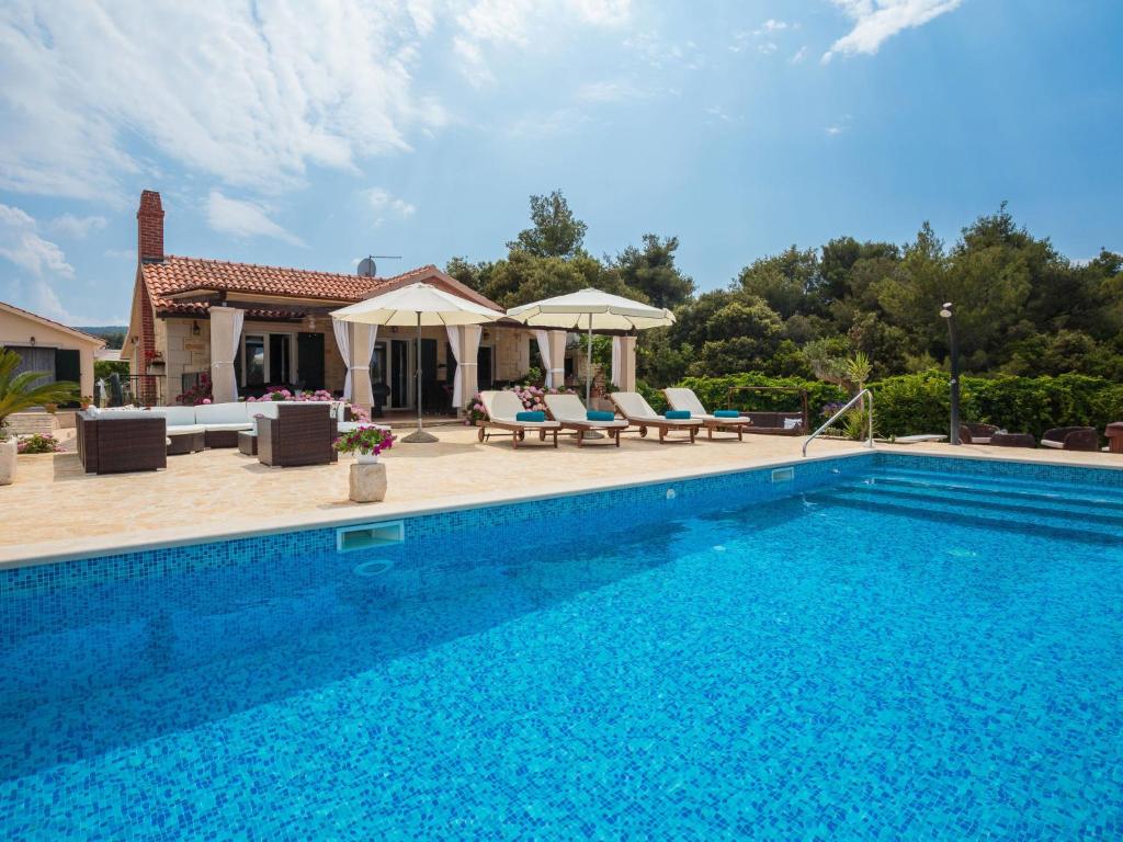 a swimming pool in front of a house at Holiday Home Villa Mutnik by Interhome in Mirce