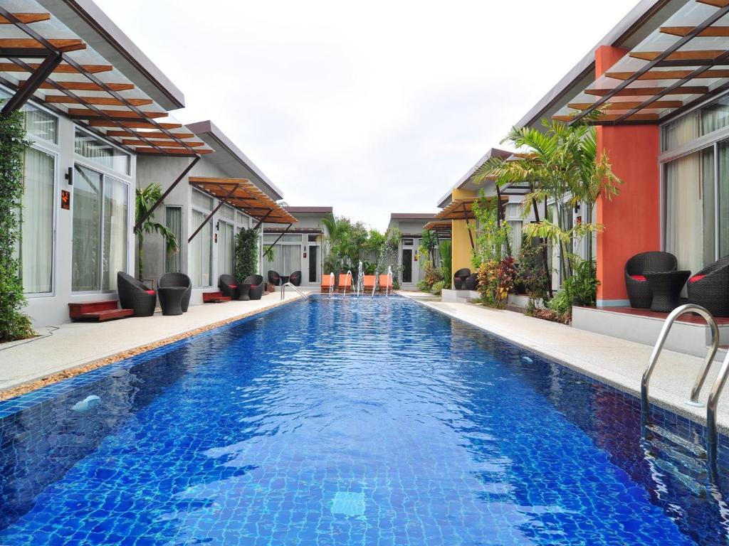 a swimming pool in the middle of a house at Phu NaNa Boutique Hotel - SHA Plus in Rawai Beach