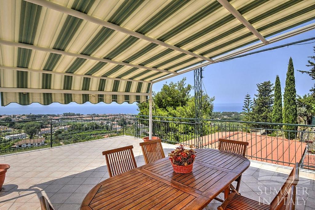 a wooden table and chairs on a patio with a view at CASA RENATA in Castellabate