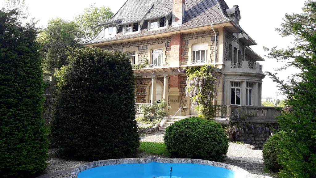 ein altes Haus mit Pool davor in der Unterkunft Hotel de France in Montbéliard