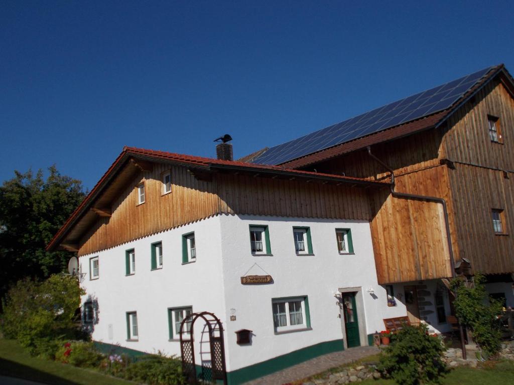 a large white house with a wooden roof at Ferienhaus Rachelblick in Kirchberg
