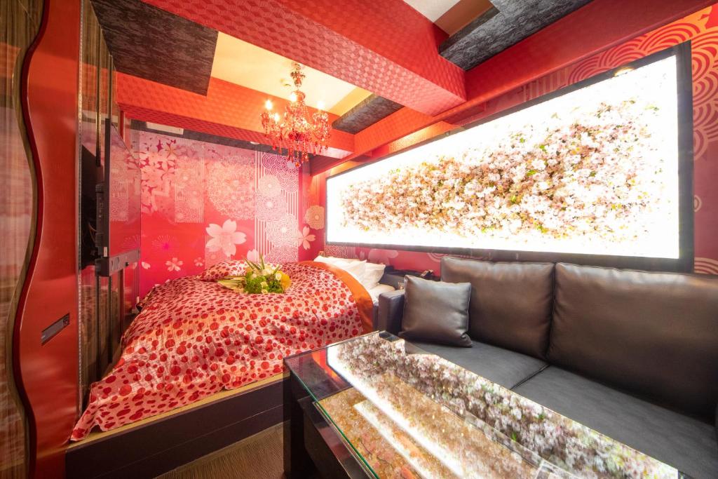 a room with a bed and a couch and a projection screen at Hotel G-Style (Adult Only) in Tokyo