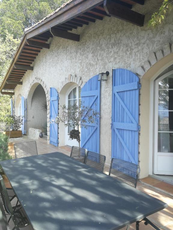 une maison avec des portes bleues sur une terrasse dans l'établissement la Cigalette, à Peypin