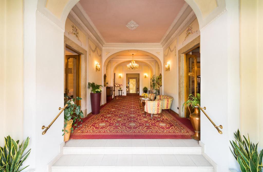 a hallway of a building with a staircase and a table at Hotel Eden in Levico Terme