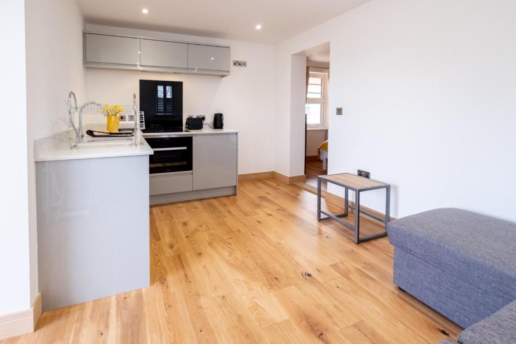 a kitchen and living room with a counter and a bed at Oak – Three Tuns Apartments in Pettistree