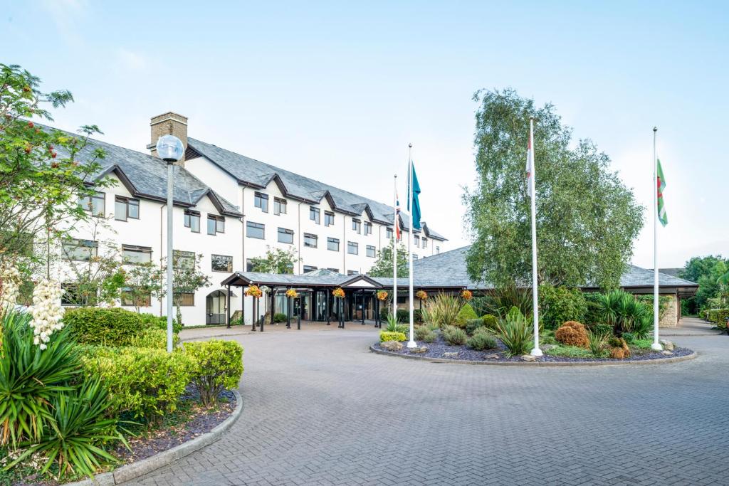 un hotel con banderas frente a un edificio en The Copthorne Hotel Cardiff en Cardiff