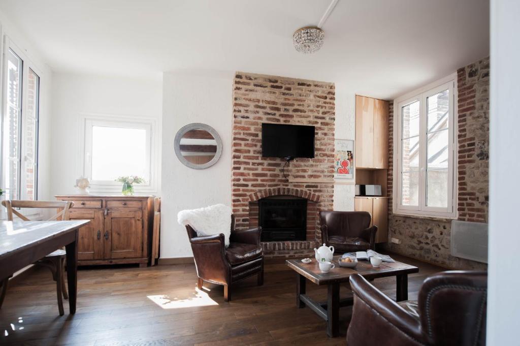 a living room with a brick fireplace and chairs at Appartement Vancouver in Honfleur