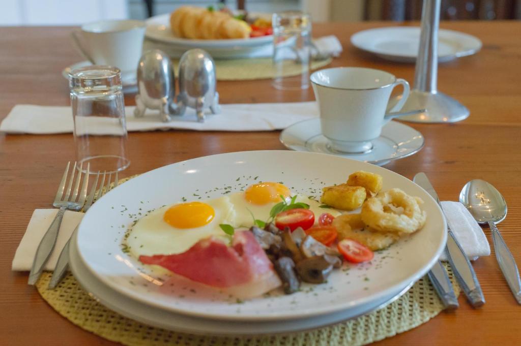 a plate of food with eggs and vegetables on a table at Osborne House in Pretoria