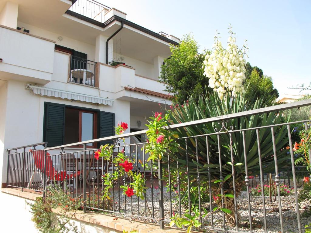 a balcony of a house with flowers and a red chair at Casa Margherita in Parghelia