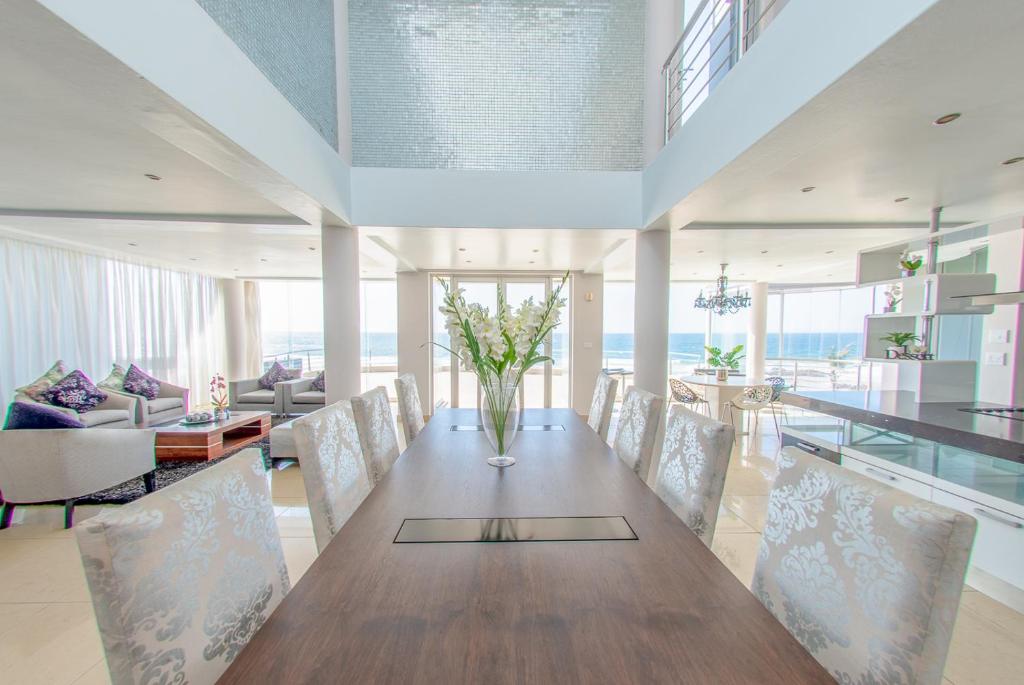 a dining room with a long wooden table and chairs at Residence on Sea View in Tinley Manor