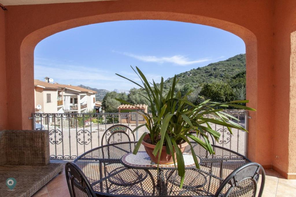 a table with a potted plant on a balcony at Villino Bordeaux in San Teodoro