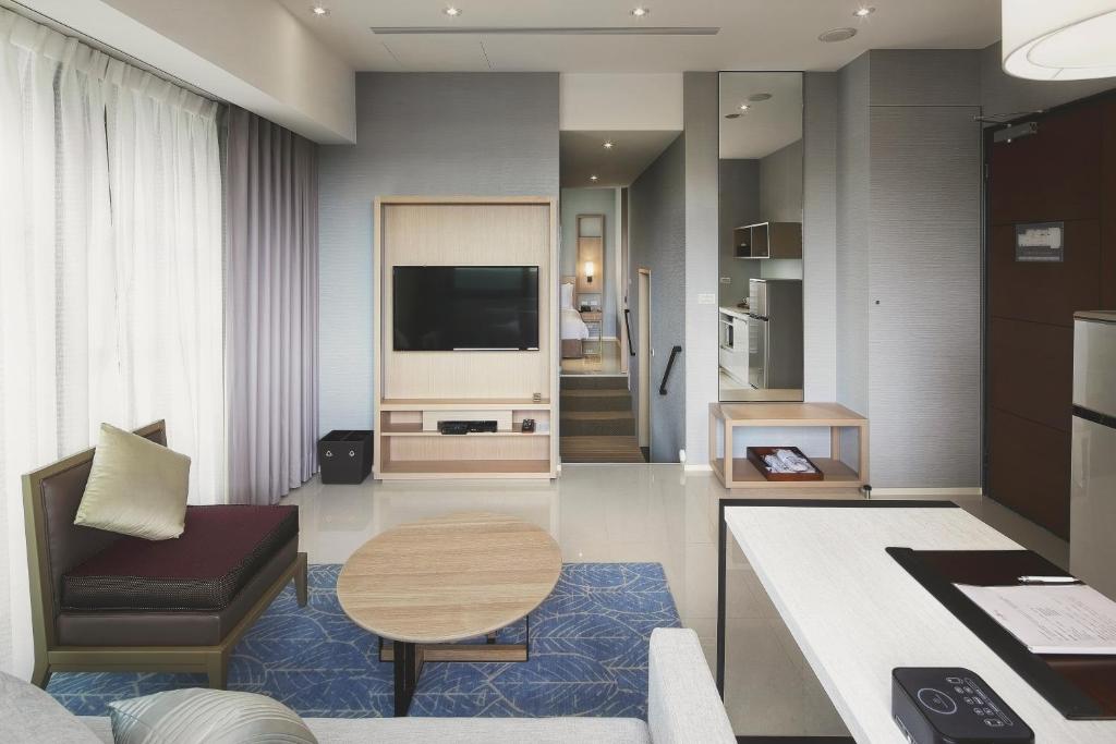 a living room with a tv and a couch and a table at Jolley Hotel in Taipei