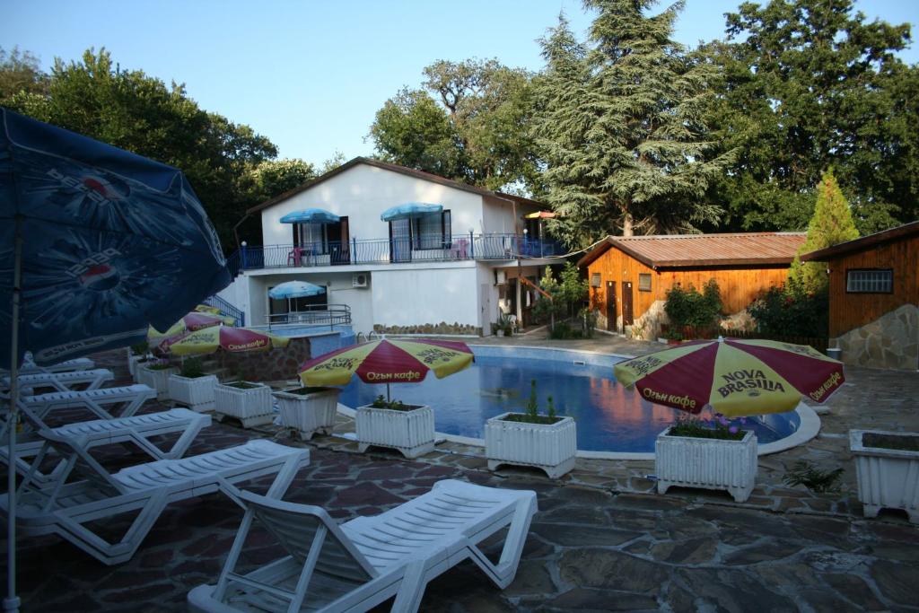 a group of chairs and umbrellas next to a swimming pool at Oasis Villas in Golden Sands